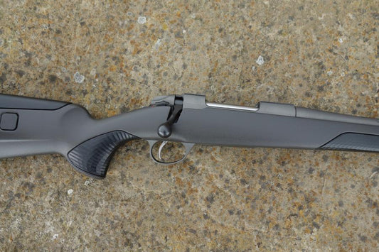 Sako 85 Finlight 2 rifle on ground, showcasing stainless steel action, fluted barrel, adjustable comb, and detachable magazine.