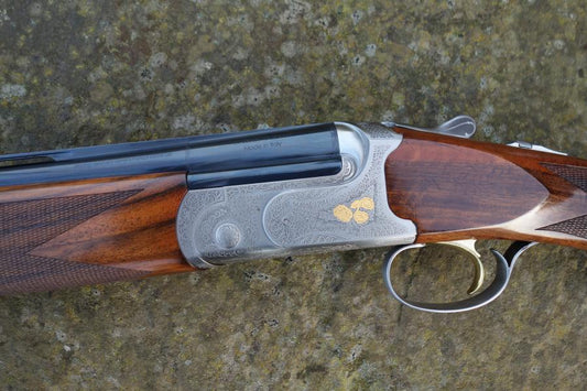 Close-up of Caesar Guerini Tempio Game gun, showing its well-figured stock, rounded pistol grip, and visible trigger, highlighting superb condition and craftsmanship.
