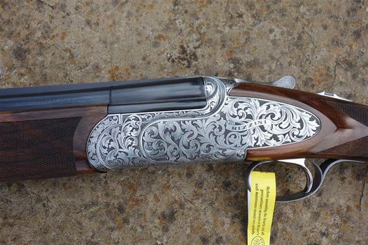B Rizzini Regal Deluxe Game gun, featuring engraved floral scrollwork, a long trigger guard, and a walnut stock with a solid rib and flush-fitting chokes.