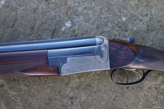 J W Lewis Live Pigeon Game firearm close-up, showcasing its trigger plate action, solid top rib, and double triggers, emphasizing its precision craftsmanship.