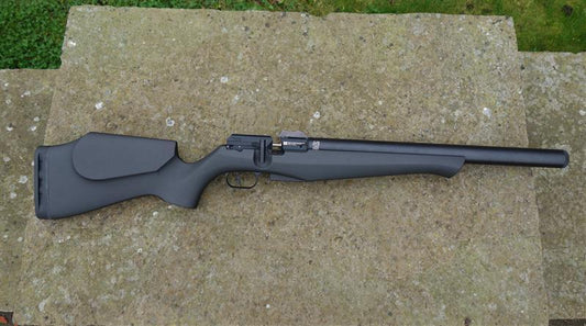FX DRS Classic Synthetic rifle on stone surface, featuring a sleek, lightweight design with a 16-shot mini magazine, offering impressive performance.