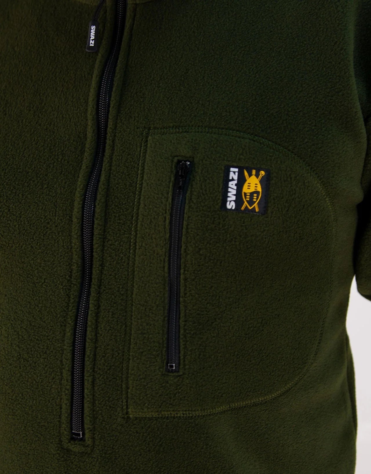 Close-up of the Swazi Bush Shirt, showcasing its long zipper and snug cuffs, emphasizing its comfort and practicality as a warm, olive fleece jumper.