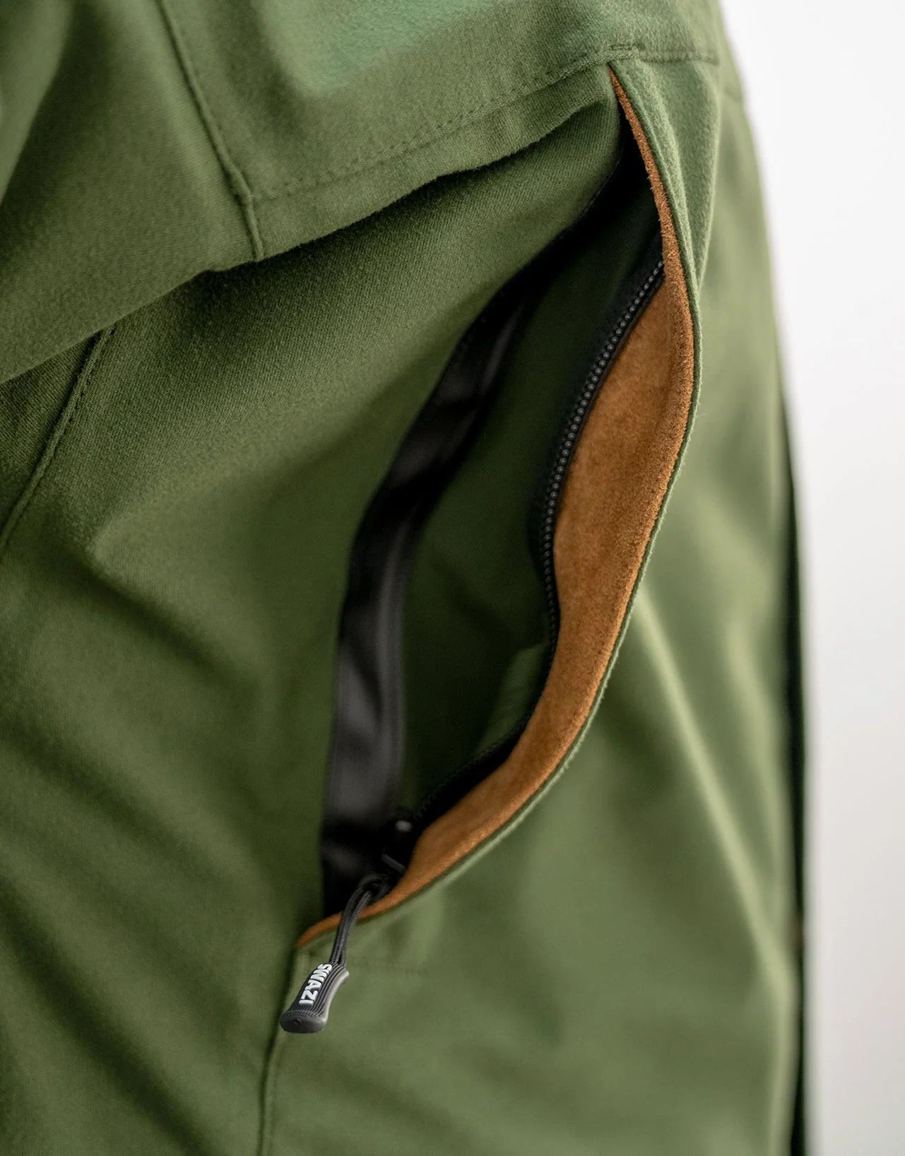 Swazi Wapiti XP Men's Hunting Jacket features close-up of water-resistant zipper and pocket, showcasing durable design for extreme weather conditions.