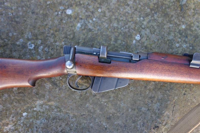 Close-up of a Lithgow SMLE MK3 firearm, showcasing its excellent woodwork, clear markings, and brass butt plate, ideal for collectors.