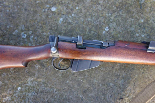 Close-up of a Lithgow SMLE MK3 firearm, showcasing its excellent woodwork, clear markings, and brass butt plate, ideal for collectors.