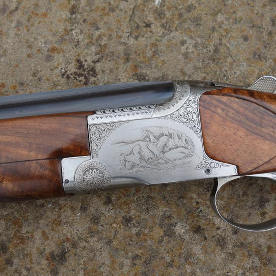 Browning B25 B2G Game shotgun, featuring a close-up of the action and barrels, leather-wrapped recoil pad, and narrow game rib, highlighting its detailed craftsmanship.