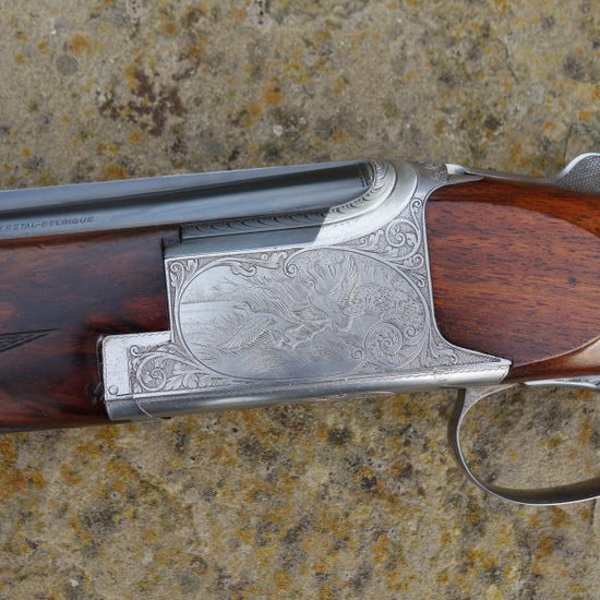 Close-up of a Browning B25 C2G Skeet gun, featuring engraved birds on the metal and a well-figured stock with a wide skeet forend.