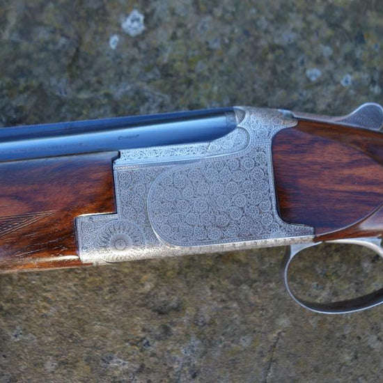 Close-up of a Browning B25 C3 Game gun, highlighting its signature Joe Wheater engraving, chrome-lined barrels, and hand-scroll engraved action.