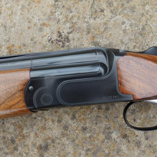 Yildiz Pro Black Gr4 Sporting shotgun, featuring a Turkish walnut stock with an adjustable comb, visible gun barrel, and trigger detail.