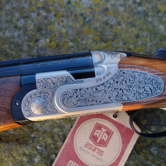 ATA Silverline Sideplate Game close-up featuring intricate folate scroll engravings, black barrels, and Turkish walnut stock with visible trigger mechanism.