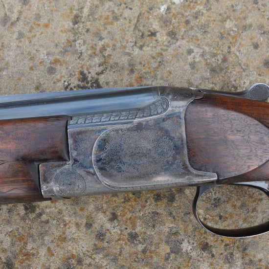 Close-up of the Browning B25 C1 Trap gun, showcasing its engraved receiver, rounded pistol grip, and narrow top rib, highlighting original features and craftsmanship.