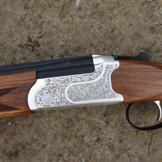 Kofs Sceptre SXE Game shotgun with silver-black handle, visible trigger, and finely figured stock, featuring HP steel proofed barrel and auto safety catch.