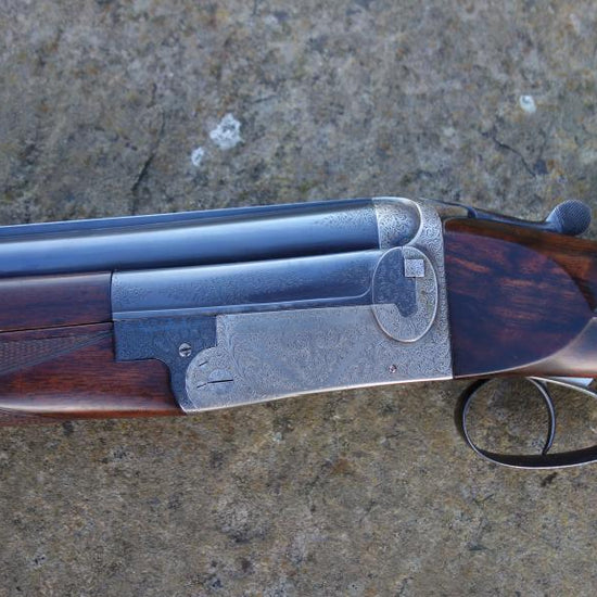 J W Lewis Live Pigeon Game firearm close-up, showcasing its trigger plate action, solid top rib, and double triggers, emphasizing its precision craftsmanship.