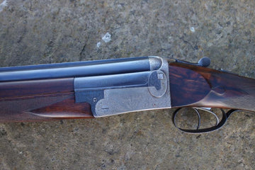 J W Lewis Live Pigeon Game firearm close-up, showcasing its trigger plate action, solid top rib, and double triggers, emphasizing its precision craftsmanship.