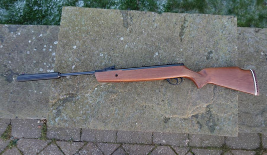 Hatsan 900X Breaker on stone surface, showcasing its springer design with hi-viz open sights and scope rail, ideal for target or small vermin shooting.