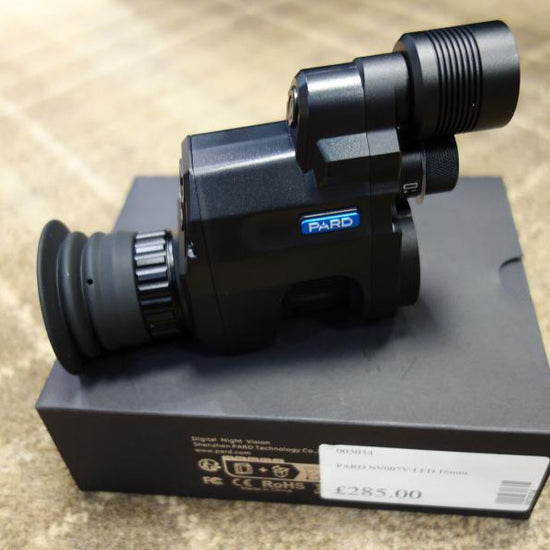 PARD NV007V 16mm Night Vision device on a box, featuring built-in LED/IR. Part of the 007 series, ideal for optical enhancement.
