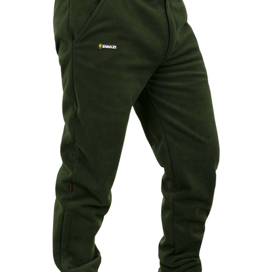 Swazi 4WD Pants | Windproof Fleece Trousers showcased worn by a person, highlighting deep pockets, logo detail, and zipper cuffs for easy wear over boots.