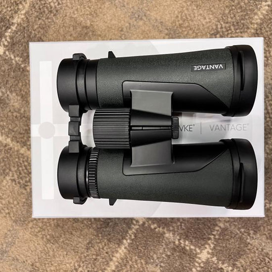 Hawke Vantage 8x42 Binoculars resting on a white box, featuring a durable design and lifetime warranty, ideal for outdoor enthusiasts seeking value and performance.