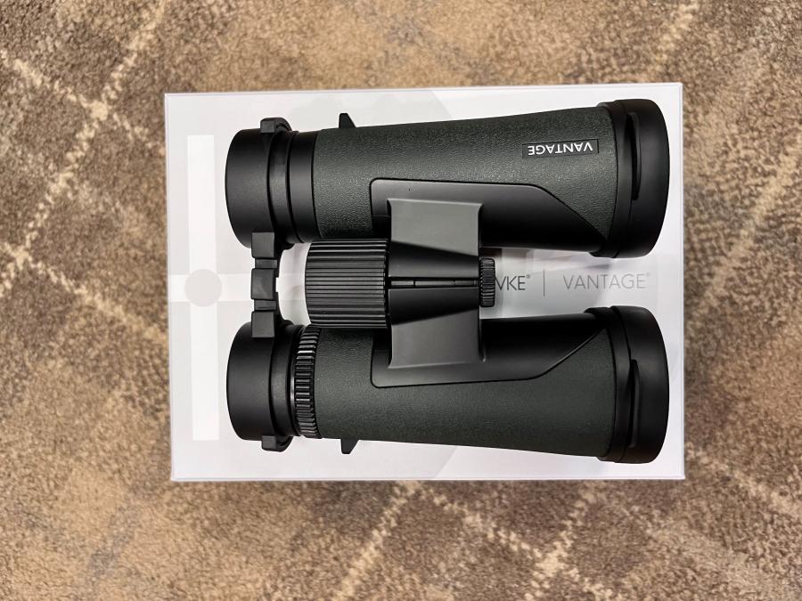 Hawke Vantage 8x42 Binoculars resting on a white box, featuring a durable design and lifetime warranty, ideal for outdoor enthusiasts seeking value and performance.