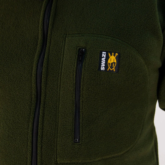 Close-up of the Swazi Bush Shirt, showcasing its long zipper and snug cuffs, emphasizing its comfort and practicality as a warm, olive fleece jumper.