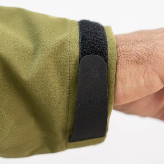 Swazi Kagoule Anorak with adjustable Velcro cuffs, large hand warmer pocket, and hood, showcased on a person, emphasizing its utility and quiet waterproof design.