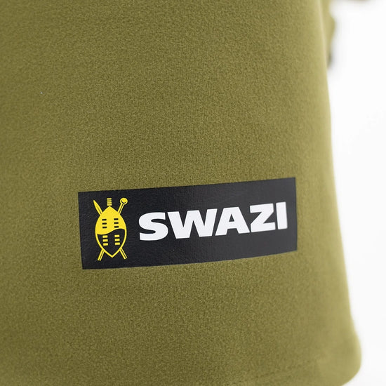 Swazi Kagoule Anorak, a quiet waterproof hunting jacket, showcases a close-up of its green fabric and distinctive logo, highlighting its durable, water-resistant features.