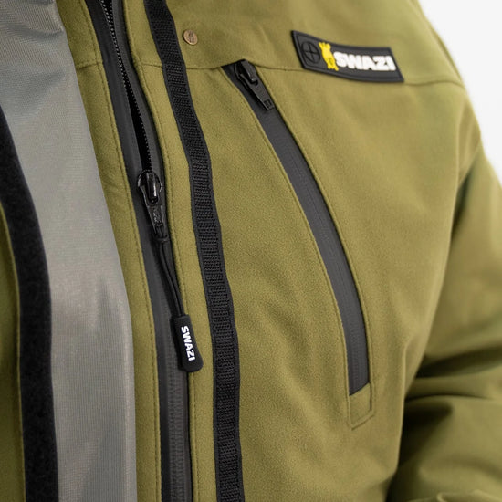 Swazi Kagoule Anorak featuring a close-up of a zipper and logo, highlighting its water-resistant YKK® zips and functional pocket design for hunting.
