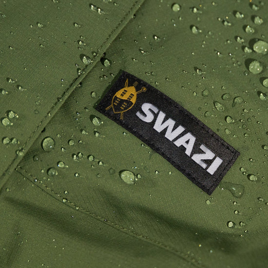 Swazi Tahr Ultralite Jacket with visible water droplets, showcasing its waterproof nature. Features include a high-vision hood and zippered chest pockets.