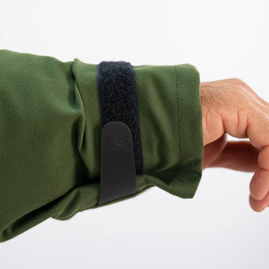 Hand adjusting Velcro strap on Swazi Wapiti XP Men's Hunting Jacket, showcasing its durable, waterproof design, ideal for harsh outdoor conditions.