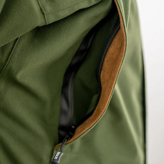 Swazi Wapiti XP Men's Hunting Jacket features close-up of water-resistant zipper and pocket, showcasing durable design for extreme weather conditions.